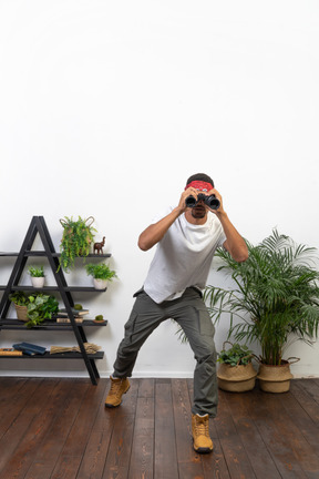 Good looking young man holding binoculars