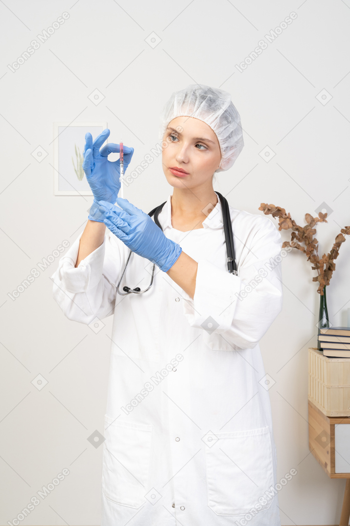 拿着注射器的一位年轻女性医生的正面图
