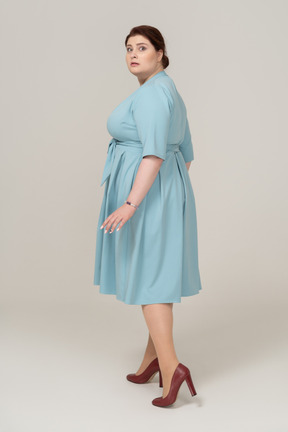 Vista lateral de uma mulher assustada em um vestido azul