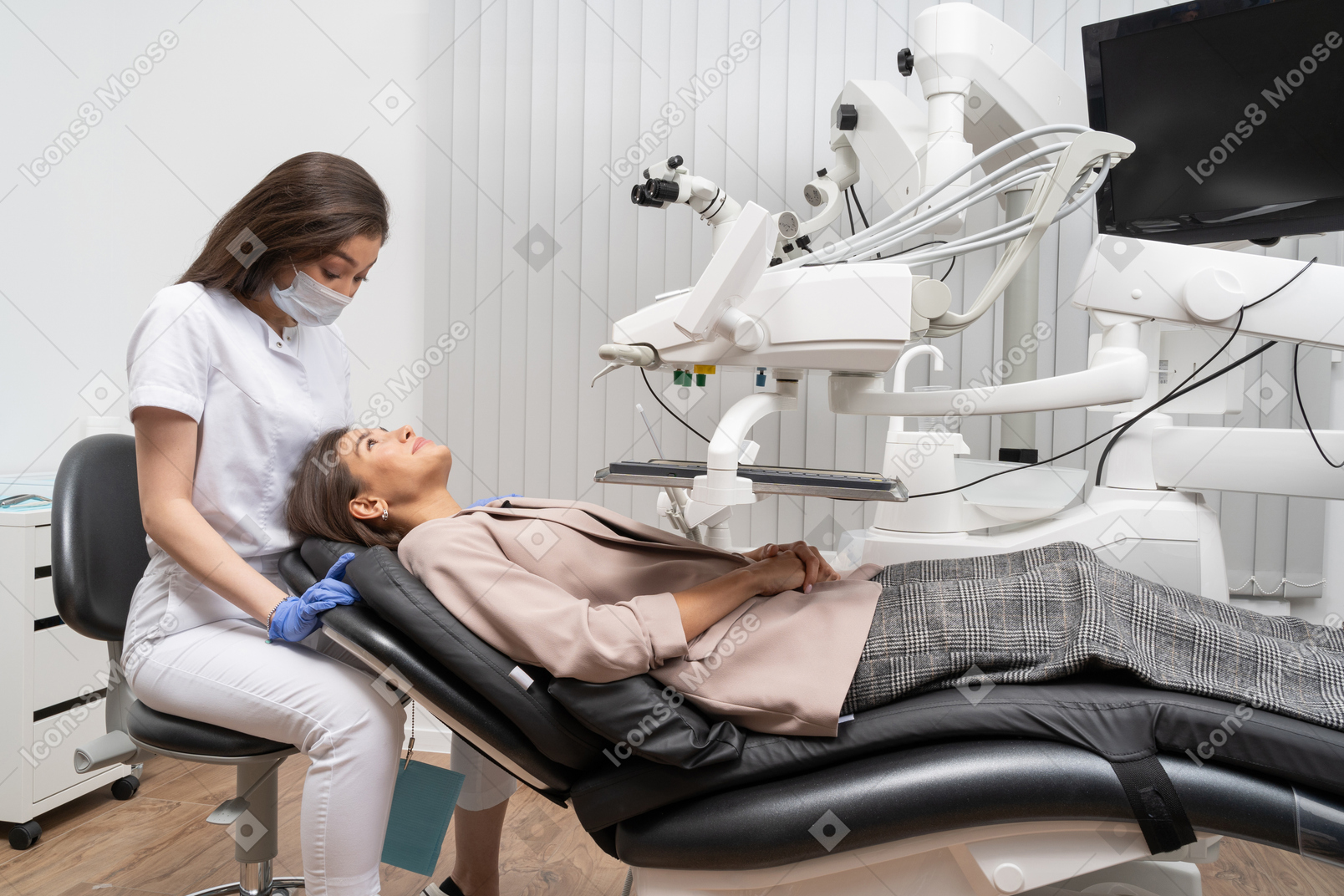 그녀의 여성 환자 검사를 준비하는 여성 치과 의사의 전체 길이