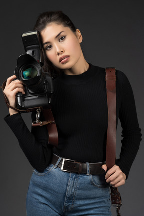 Молодая красивая женщина позирует с камерой