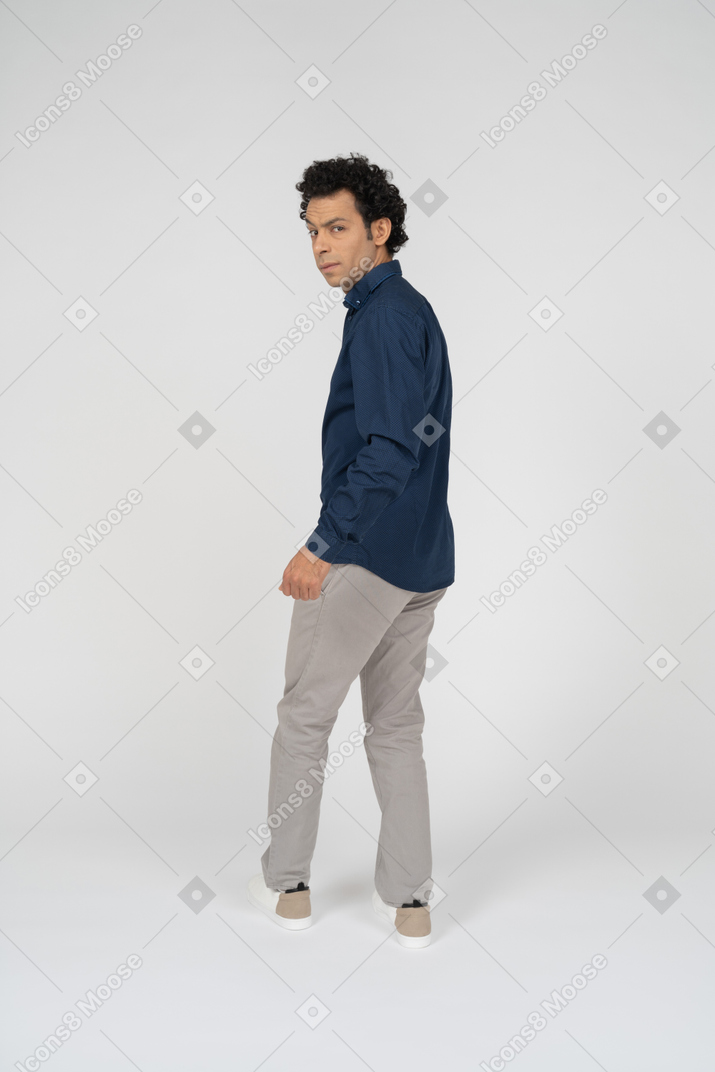 Rear view of a man in casual clothes looking at camera