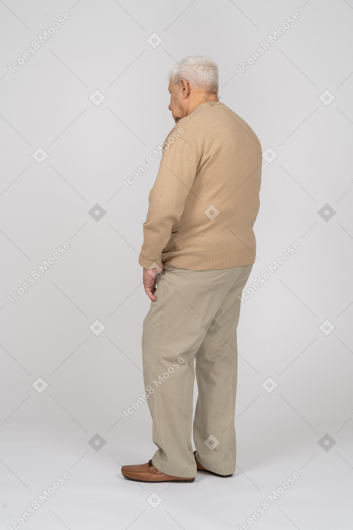 Вид сбоку на старика в повседневной одежде, стоящего на месте