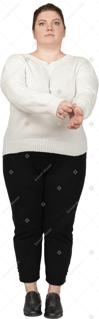 Vista frontale di una donna plus size in abiti casual che si arrotola la manica