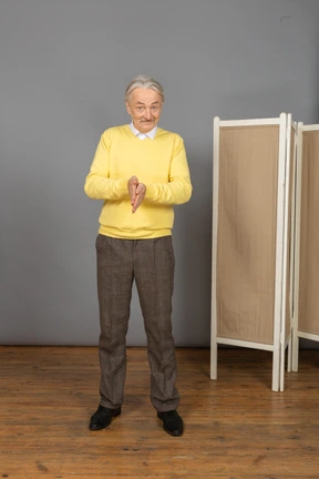 Front view of a smiling old man rubbing hands