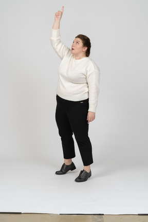 Vista frontal de una mujer de talla grande en ropa casual de pie con el brazo levantado