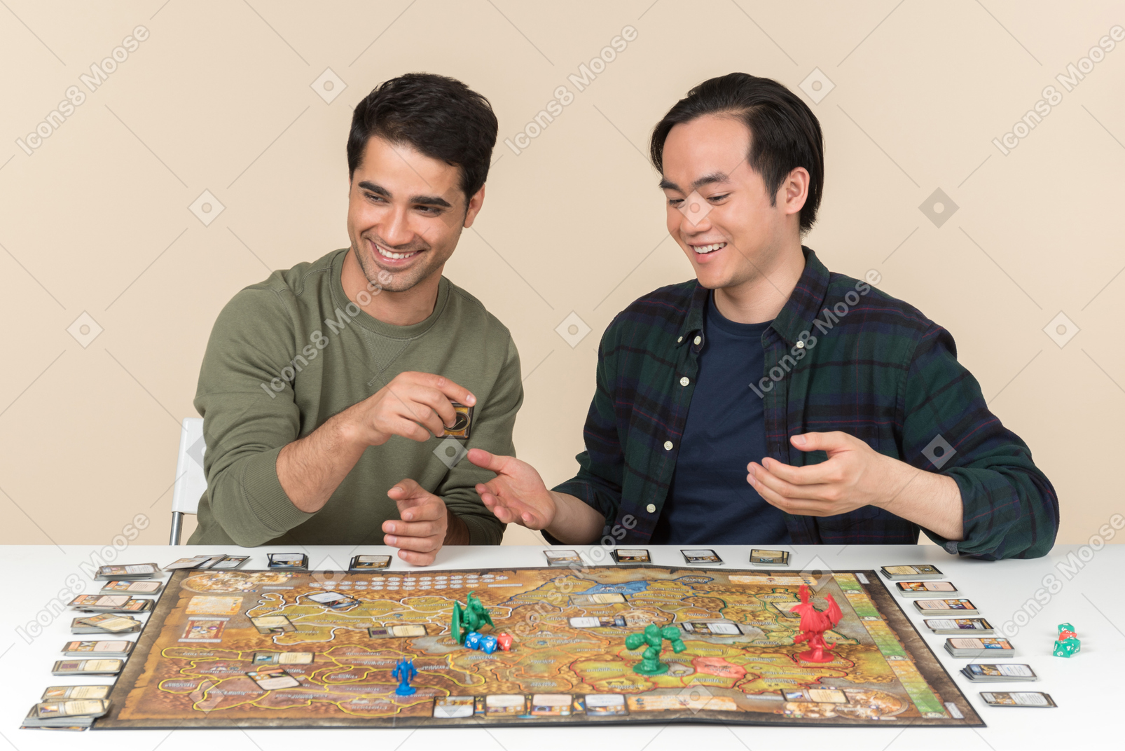 Laughing interracial friends sitting at the table and playing board game