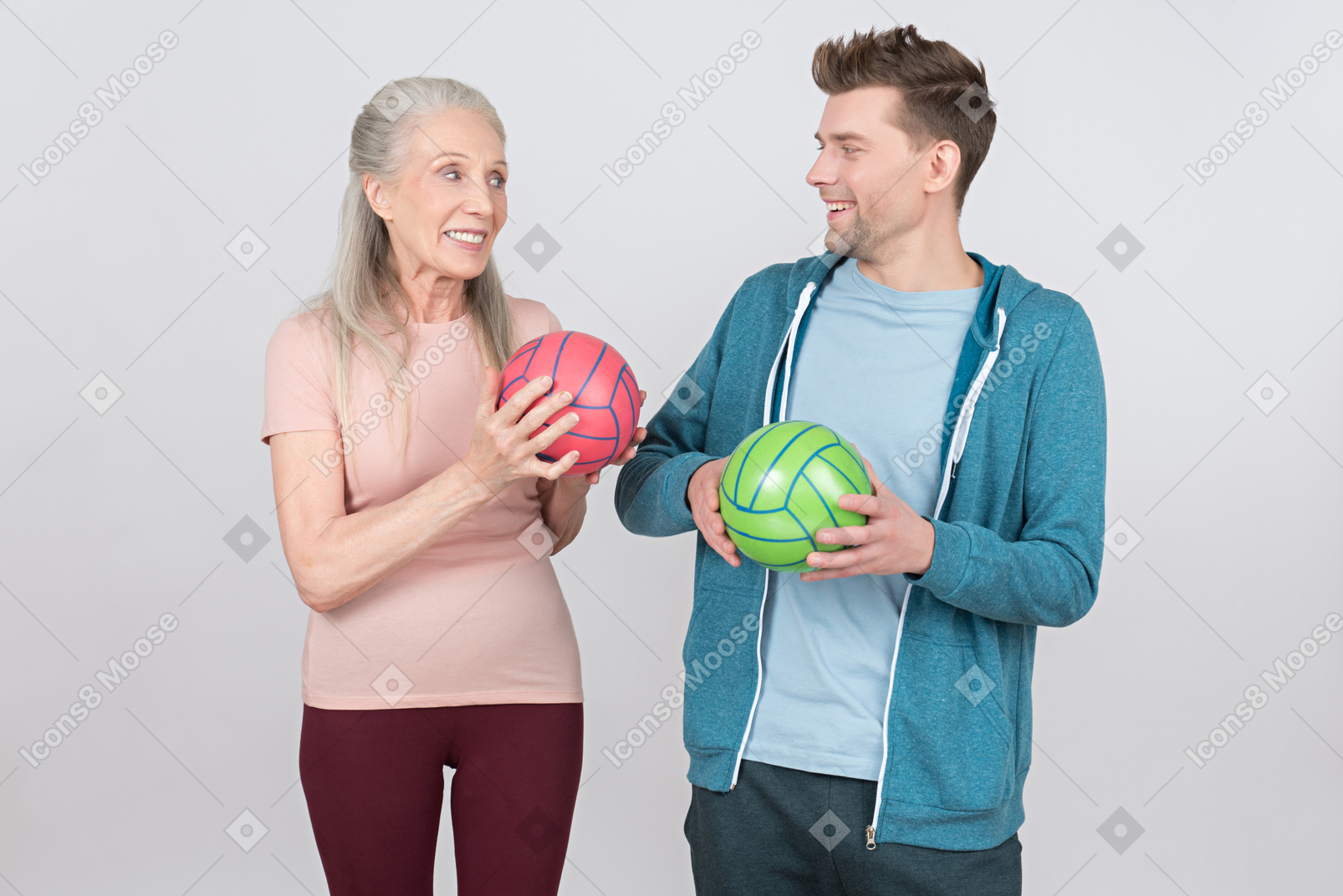 Smiling old woman and young guy holding colorful balls