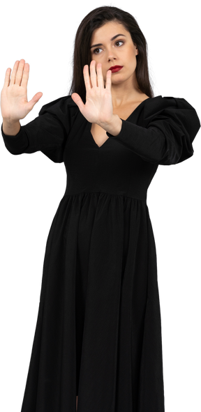 Трехчетвертный вид отвергающей молодой леди в черном платье