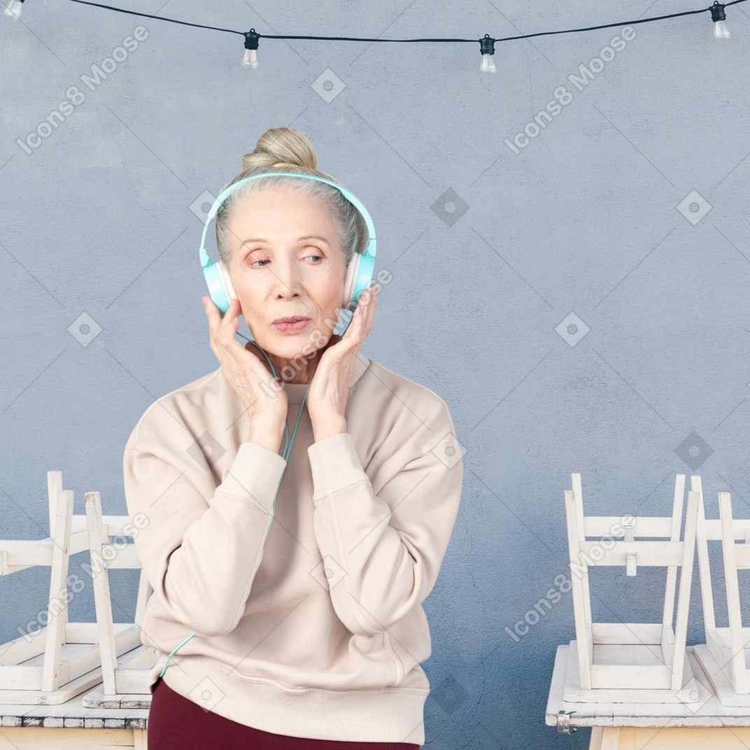 An older woman listening to music with headphones