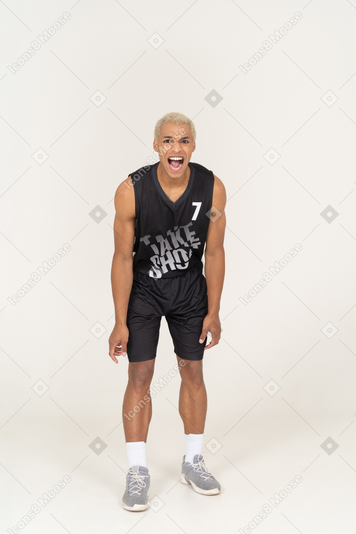怒って叫んでいる若い男性のバスケットボール選手の正面図
