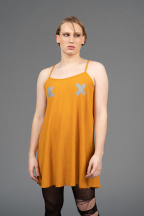 Portrait d'une jeune personne non binaire vêtue d'une robe orange