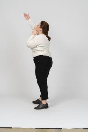 Side view of a plump woman in casual clothes with raised arm