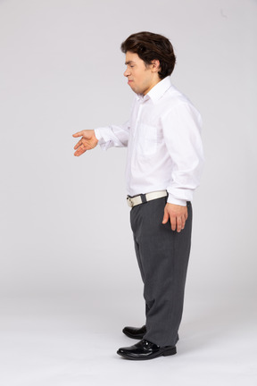 Young man in business casual clothes gesturing with eyes closed