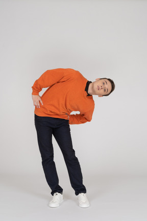 Young man in orange sweatshirt standing