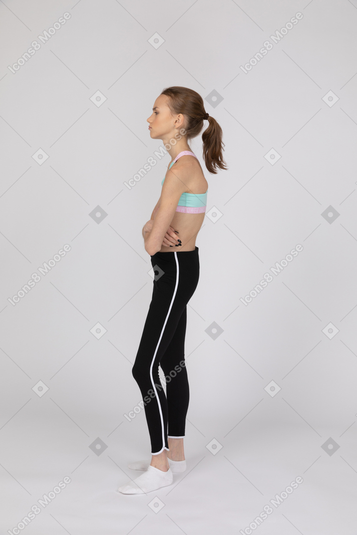 Vista lateral de una adolescente cansada en ropa deportiva.