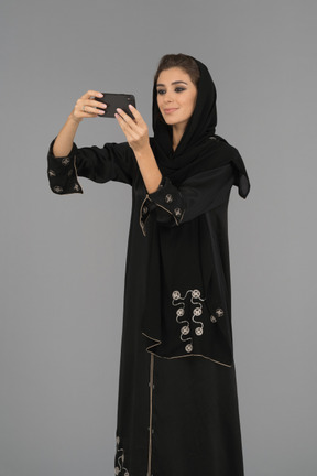 Femme arabe couverte faisant un selfie