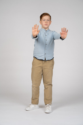Вид спереди мальчика, стоящего с вытянутыми руками