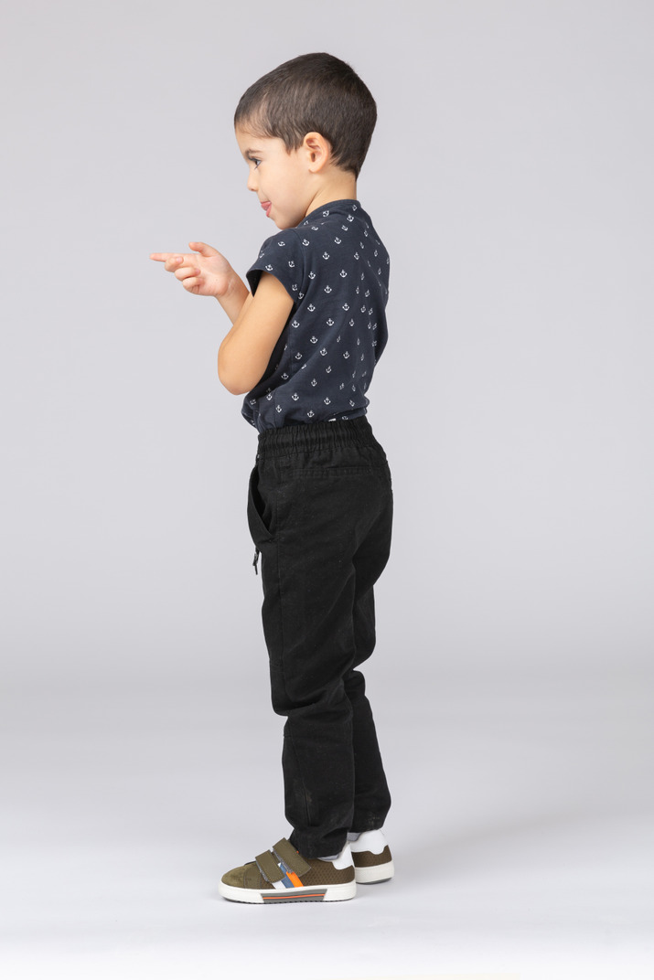 Side view of a cute boy pointing with finger