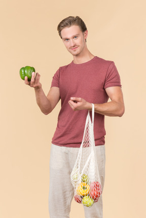 Young guy holding a string bag with groceries