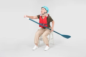 Mature woman in helmet sitting and learning how to paddle