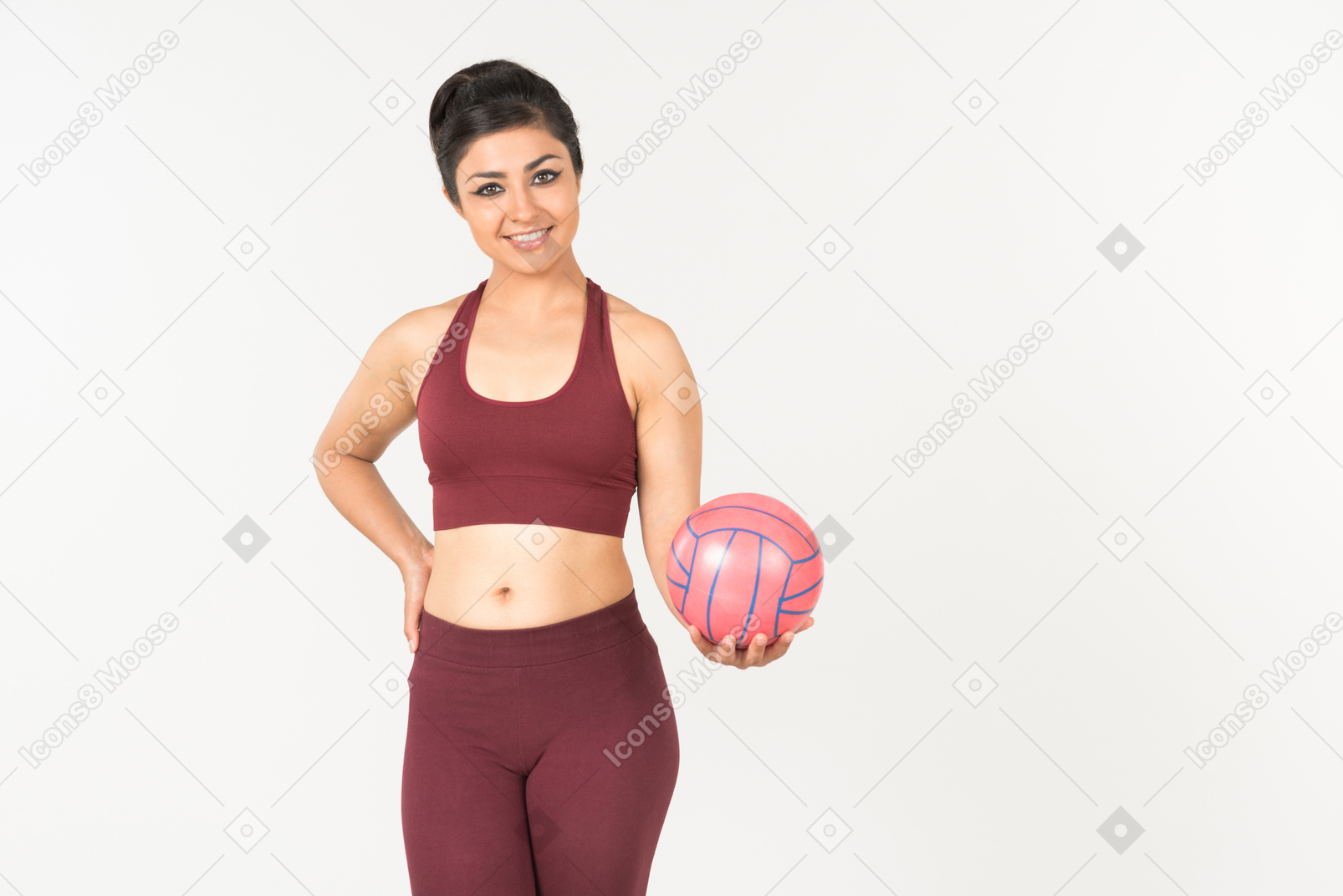 Молодая индийская женщина в спортивном костюме держит розовый шар