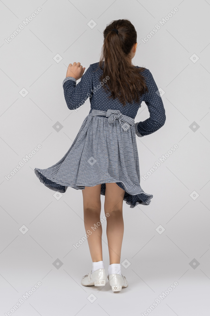 Back view of a girl waving in motion