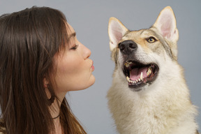 Primo piano di un maestro femminile che bacia il suo cane