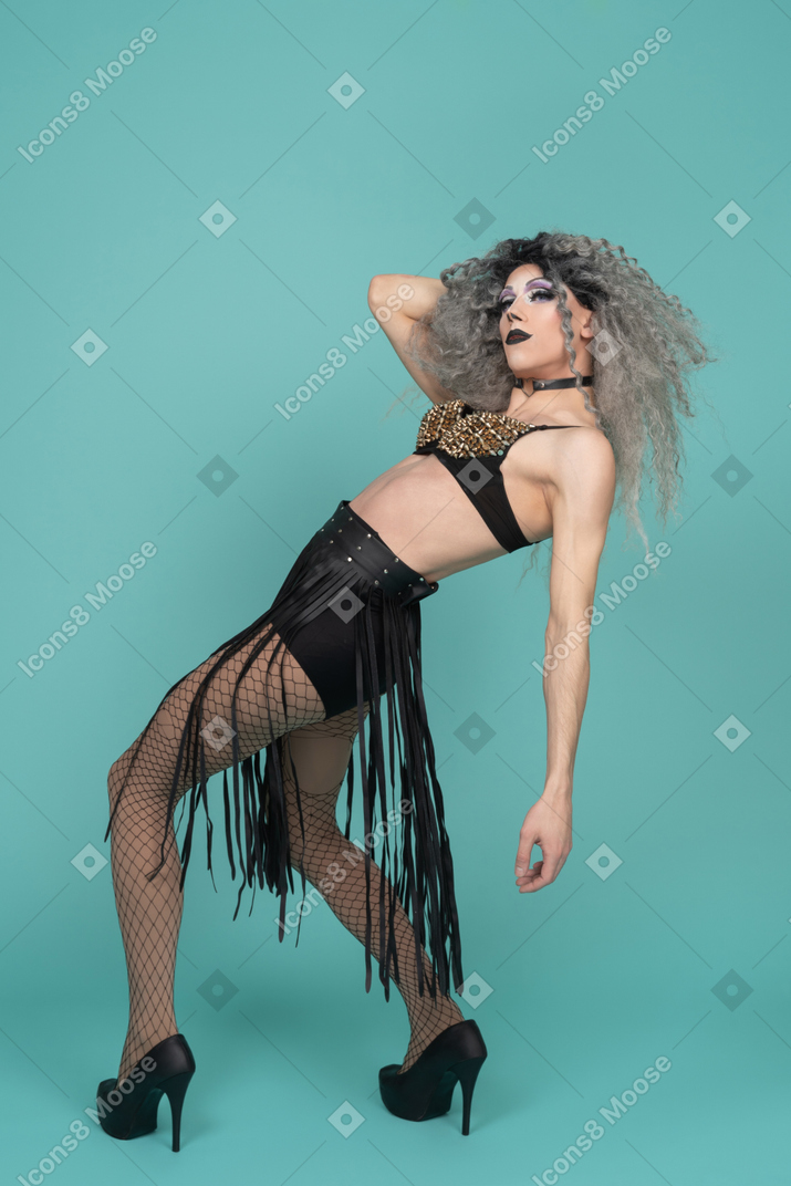 Vista lateral de una drag queen inclinada hacia atrás con la mano detrás de la cabeza