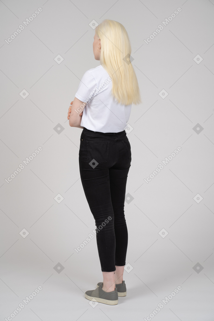 Vista posteriore di una giovane ragazza con le braccia conserte