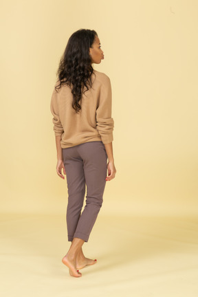 Back view of a young female in casual clothes pouting