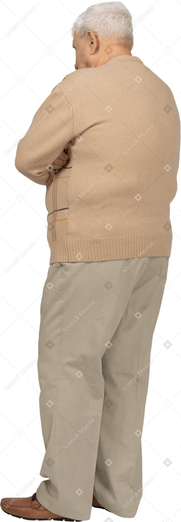 Seitenansicht eines alten mannes in freizeitkleidung, der mit verschränkten armen steht