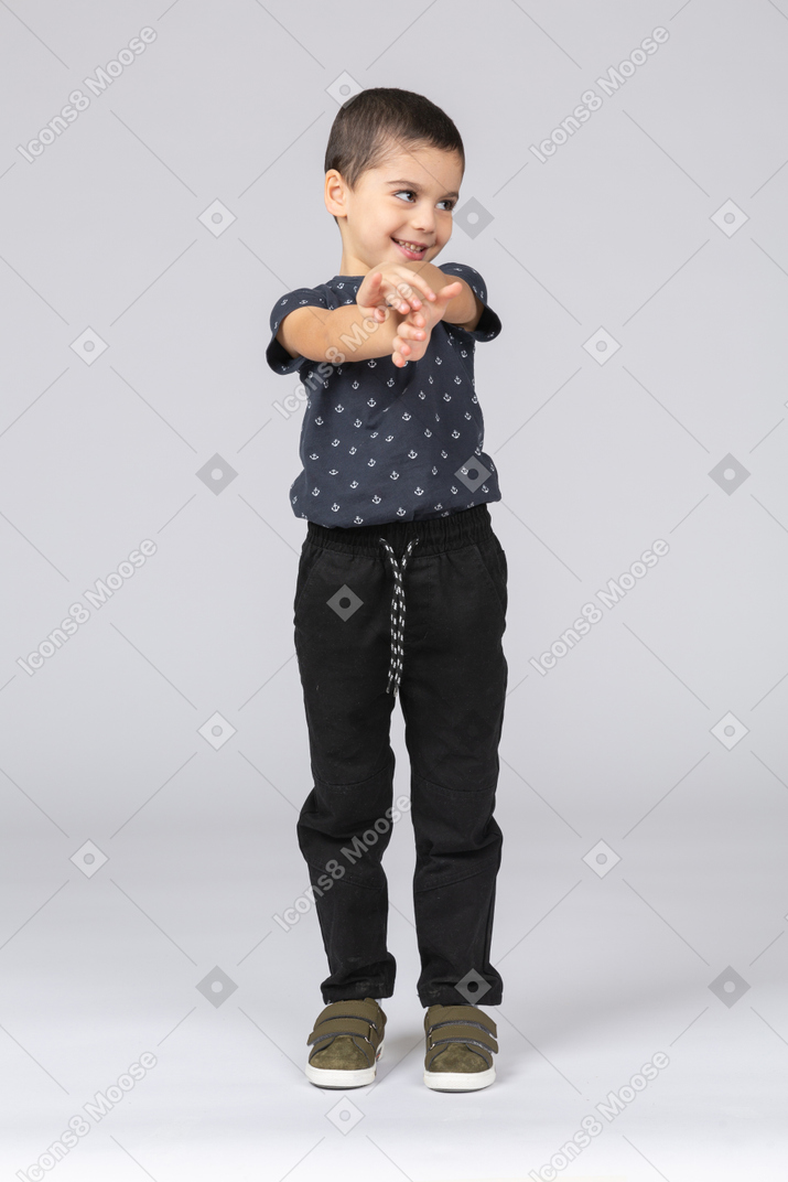 Front view of a happy boy standing with extended arms