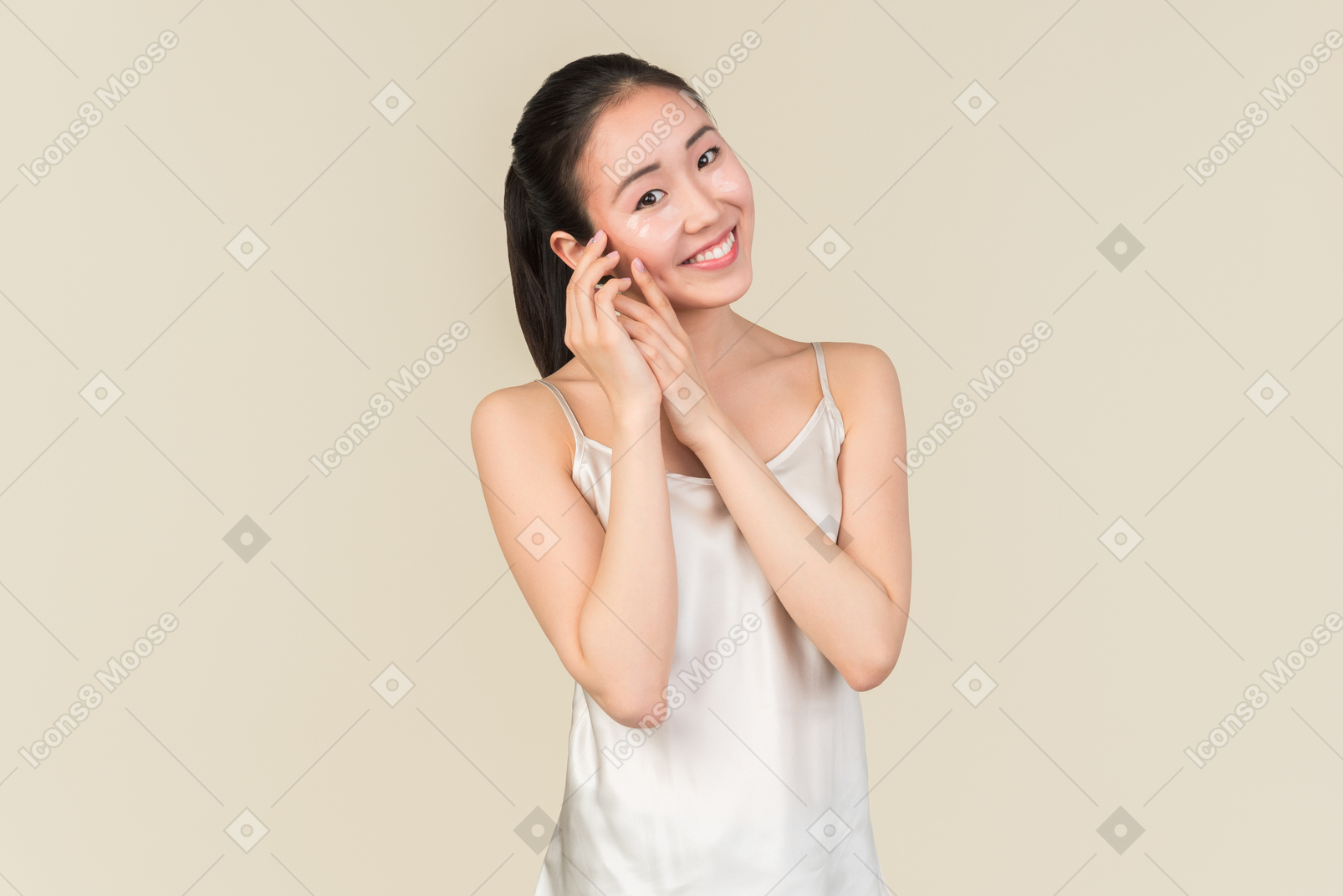 Asian girl with eye patches holding hands close to her face