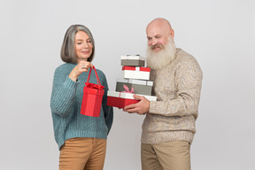 Hombre de edad dando regalos a una mujer madura elegante