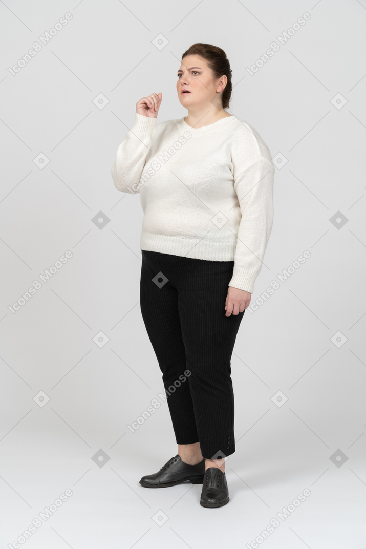 Femme dodue réfléchie dans des vêtements décontractés