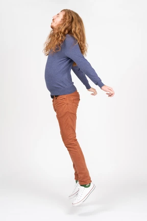Side view of a young man in casual clothes jumping