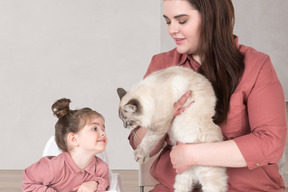 A woman and a little girl playing with a cat