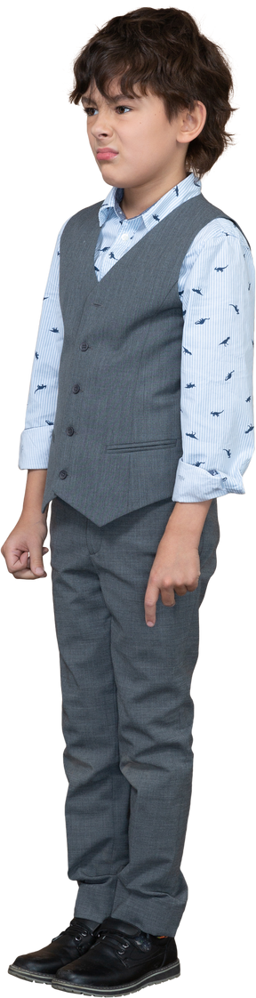 Front view of a sad boy in grey suit standing still