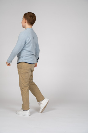 Vista lateral de um menino andando