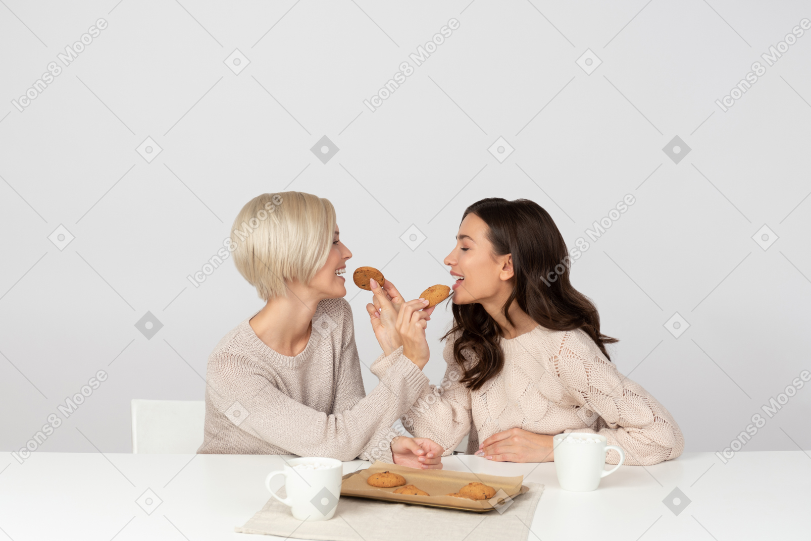 Young women feeding each other with cookies