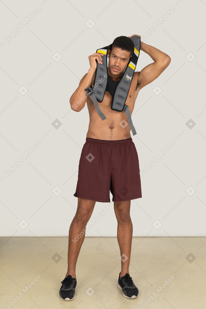 A frontal view of the athletic guy wearing a life vest and looking to the camera