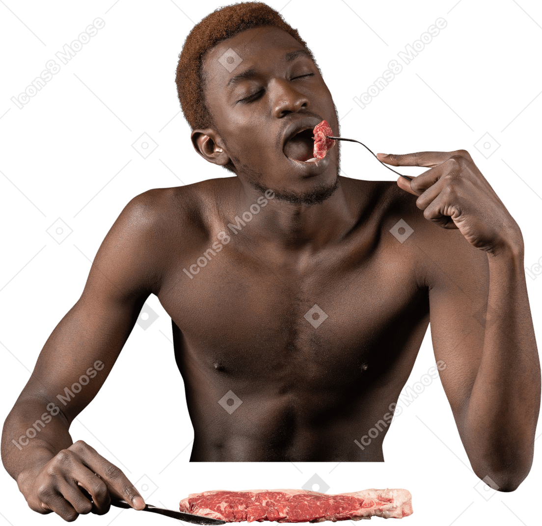 一个年轻的非洲人吃生肉的前视图