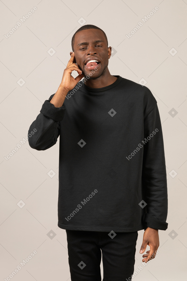 Young man talking on the phone and licking his teeth