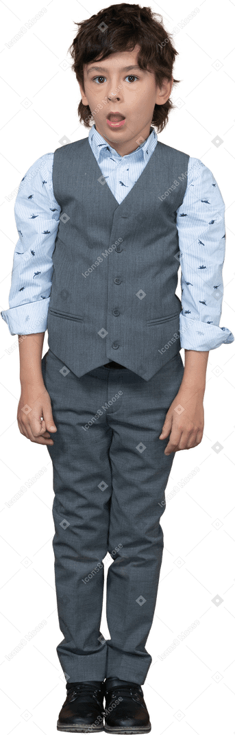 Vue de face d'un garçon mignon en costume gris debout avec la bouche ouverte