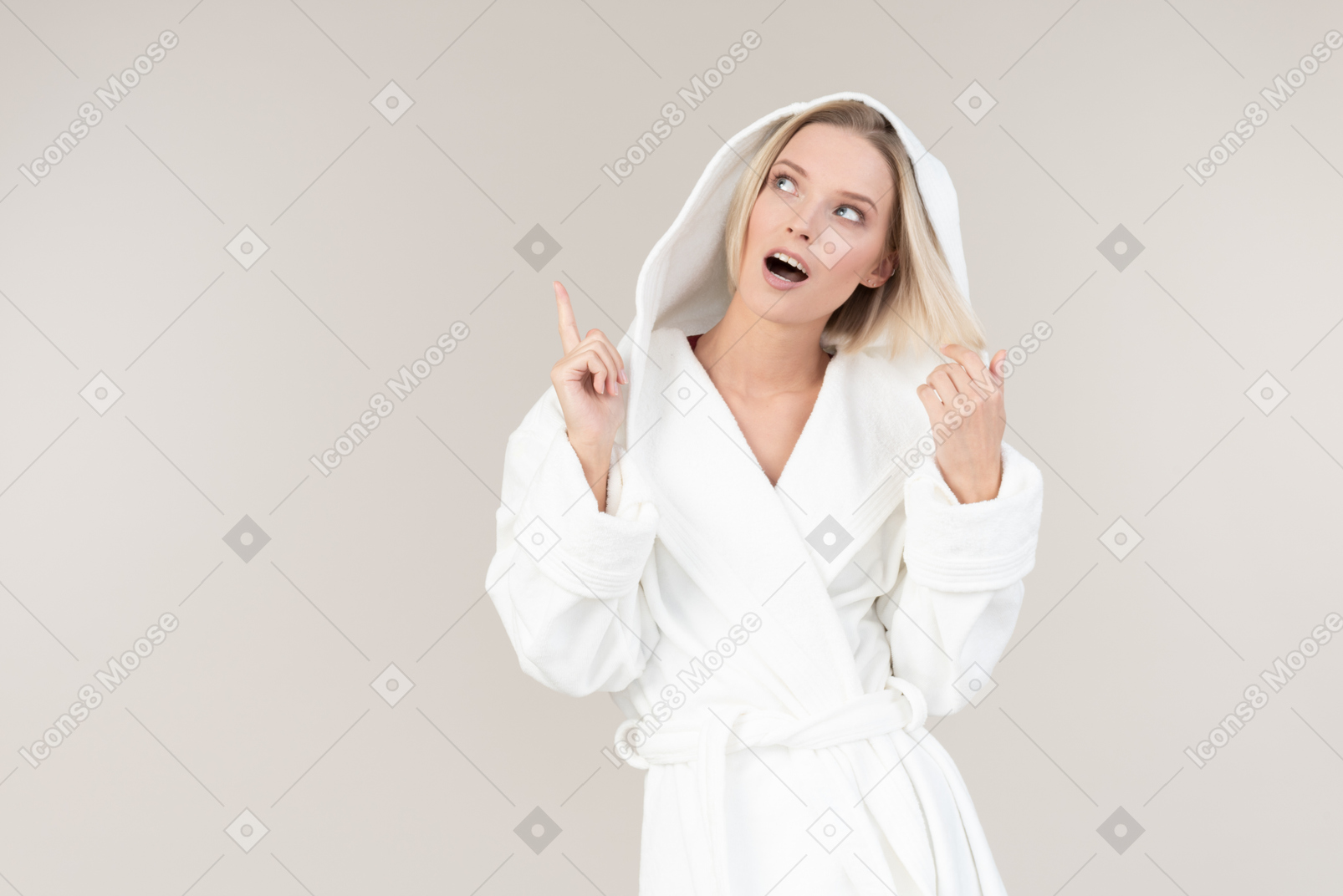 Catchy young woman in bathrobe pointing up