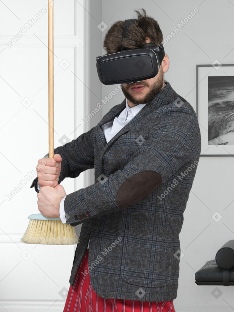 A man in a suit holding a broom and wearing a virtual headset