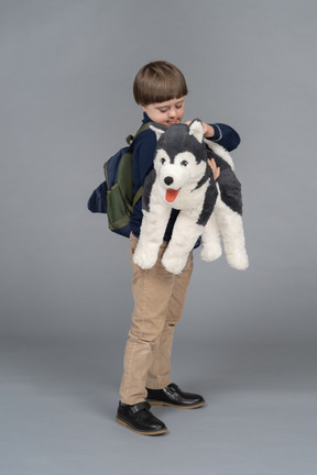 Ragazzino con uno zaino che tiene un cane di peluche