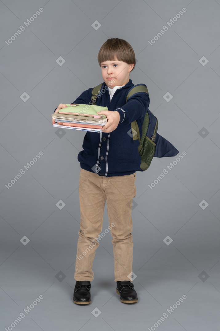 Portrait of a schoolboy holding a pile of books