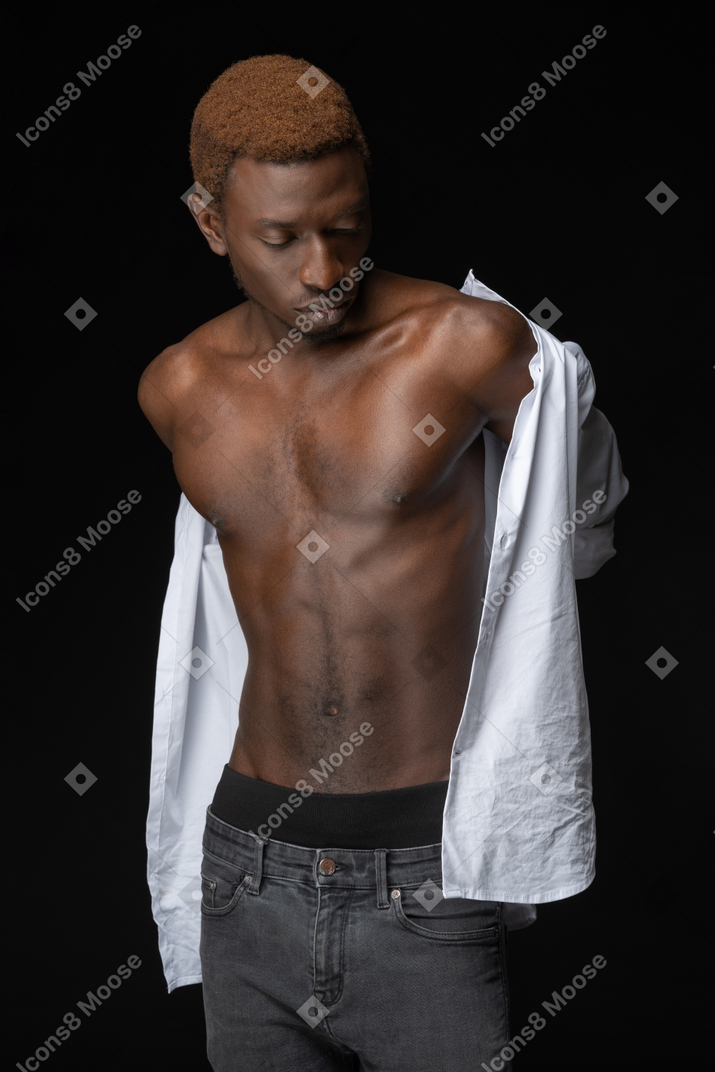Close-up young african male fitting a shirt